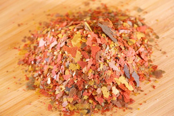 Heap of dry complete multi-ingredient flake food for daily feeding of all ornamental fish