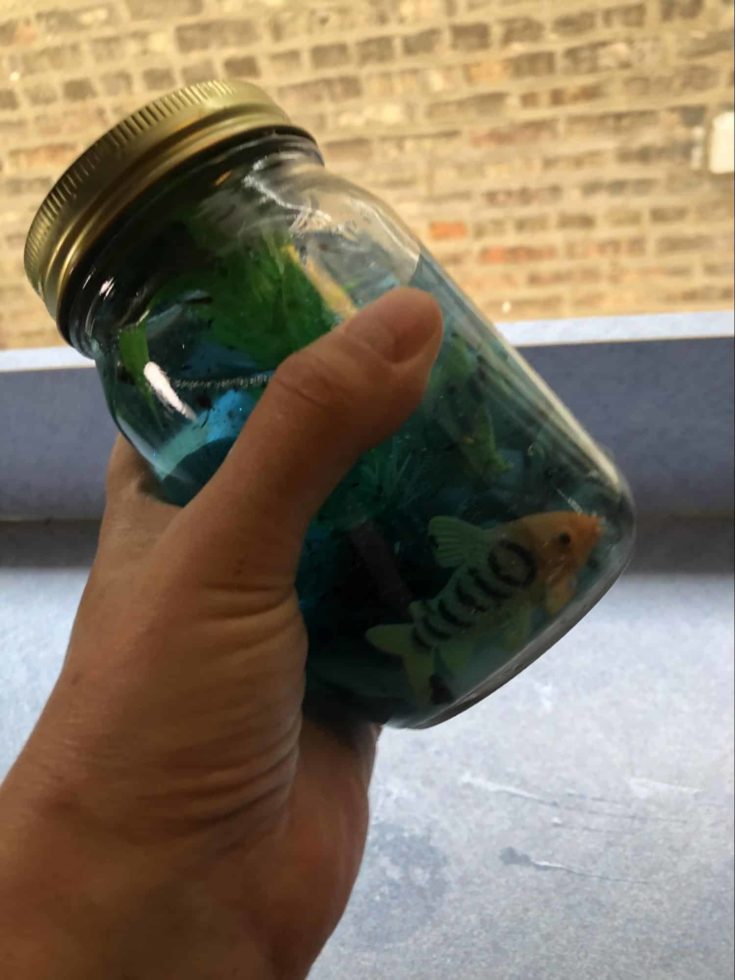 Hand shaking the DIY Aquarium jar to mix the glitters.