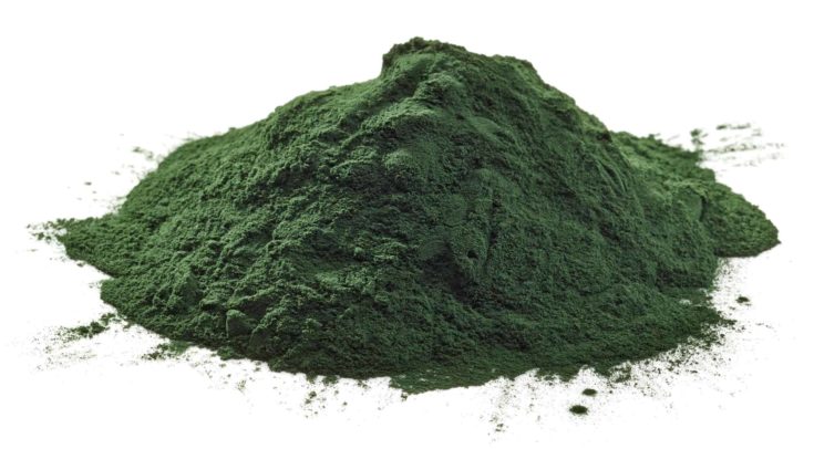 Stack of spirulina algae powder isolated on white background